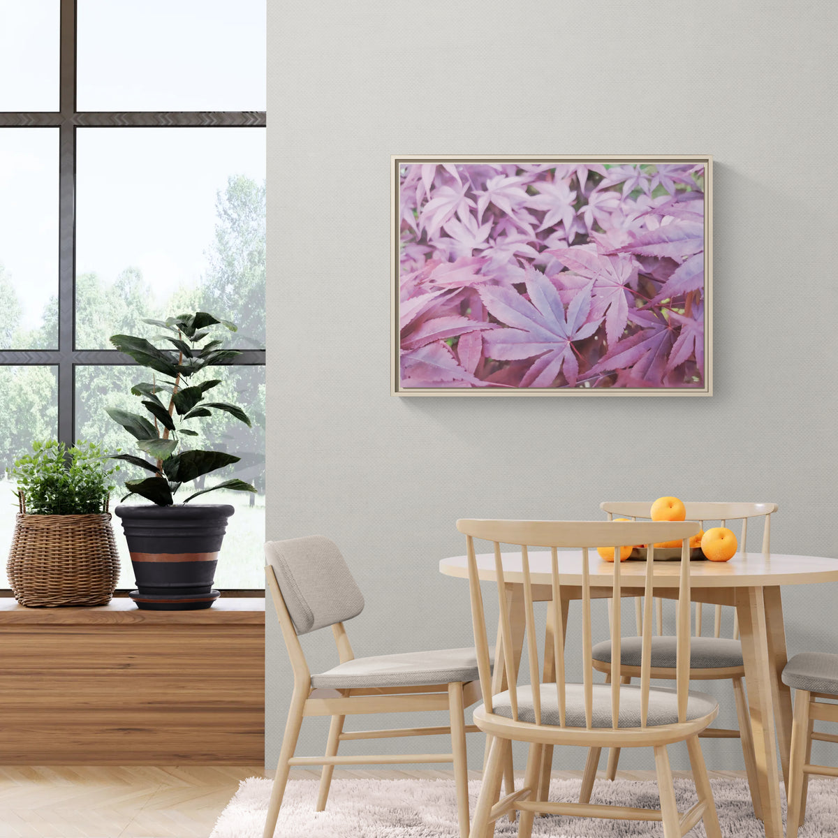 Framed wall art of purple maple leaves hanging in a dining room with wooden furniture and a large window