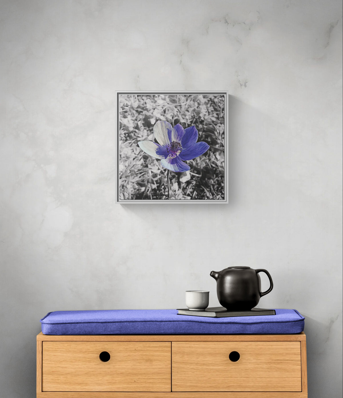 Square framed wall art featuring a purple flower on a black and white background above a wooden bench