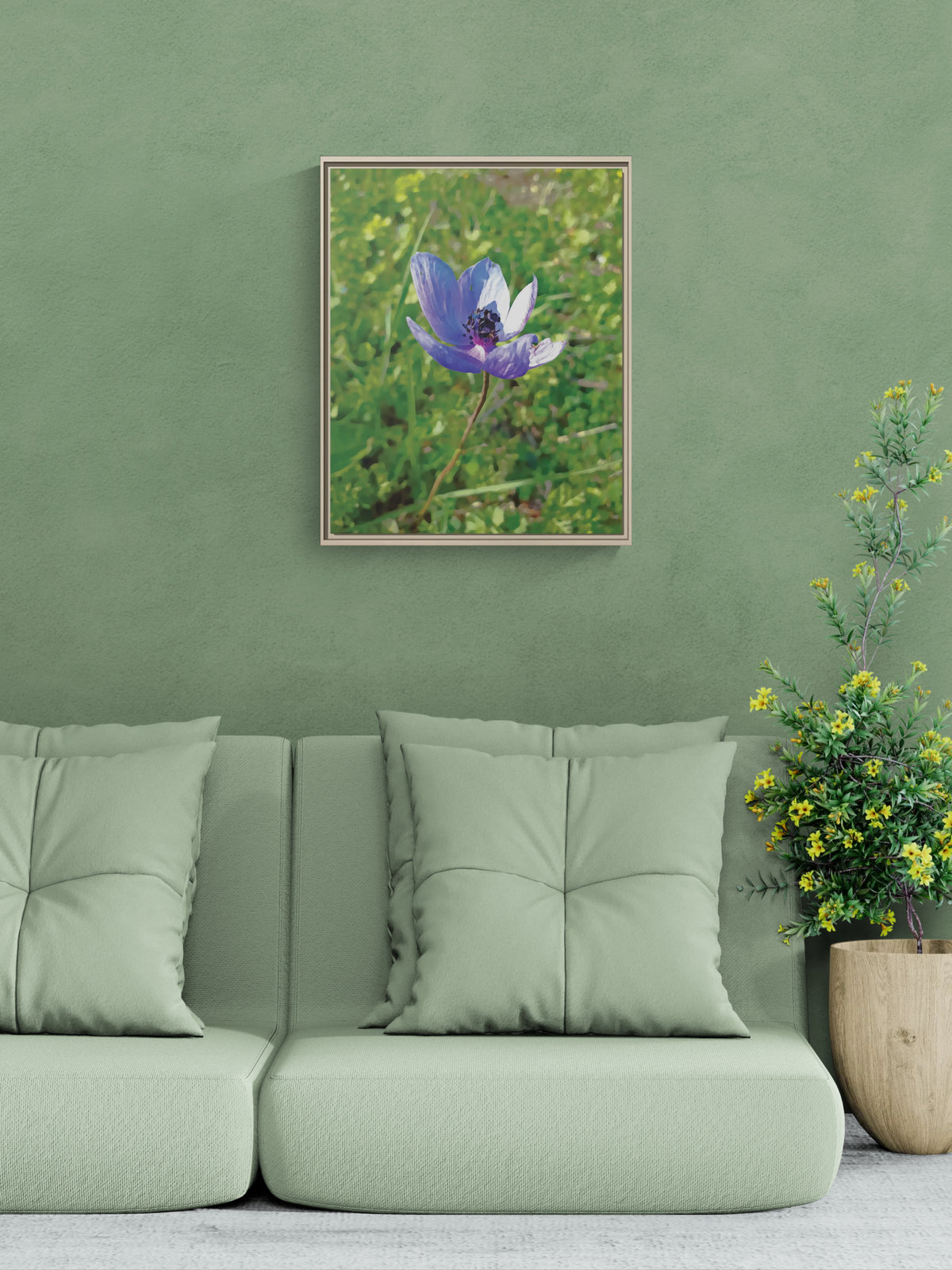 Framed wall art of a purple flower hanging above a sage green sofa with a potted plant