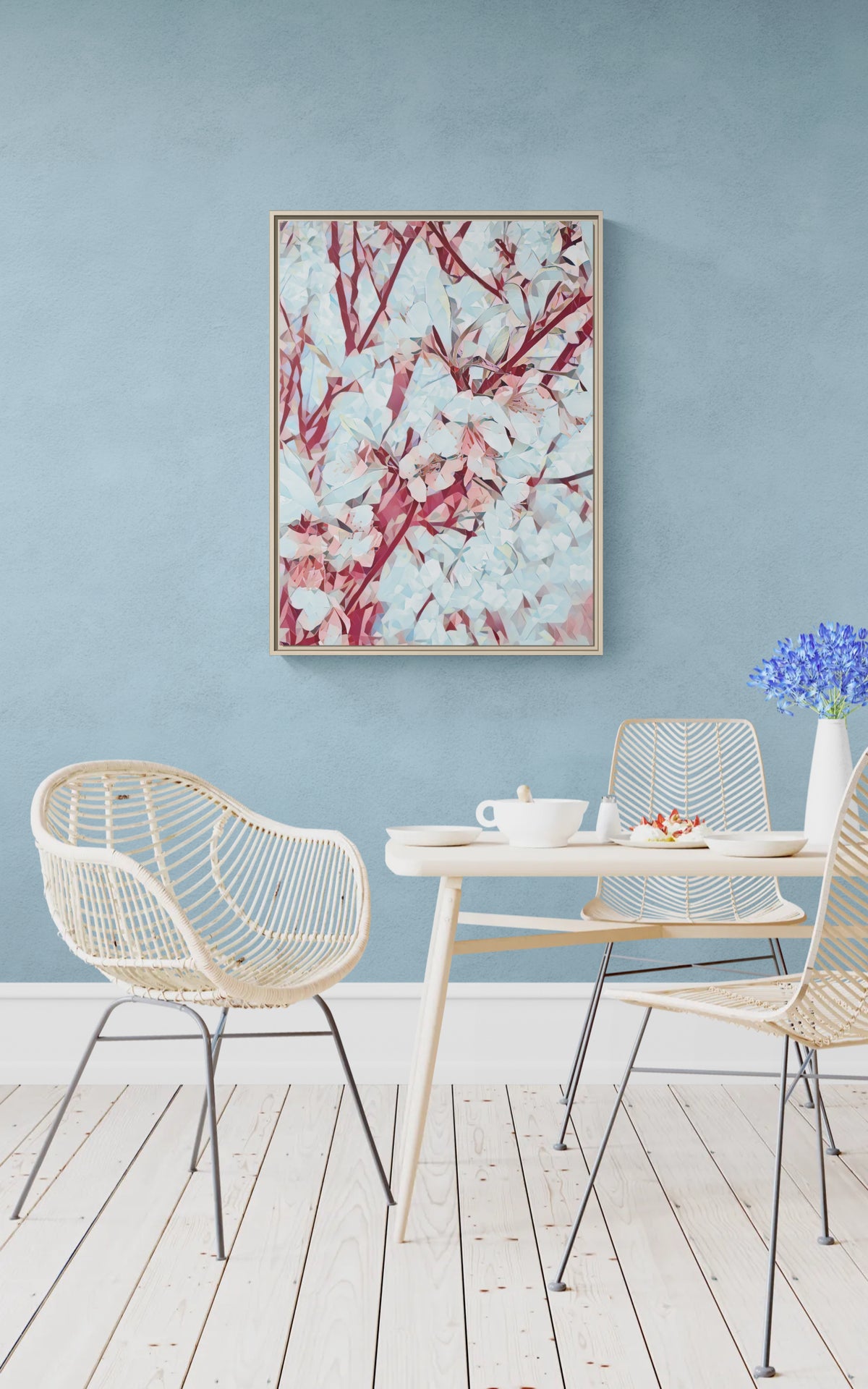 Framed abstract floral wall art hanging above a dining table with rattan chairs