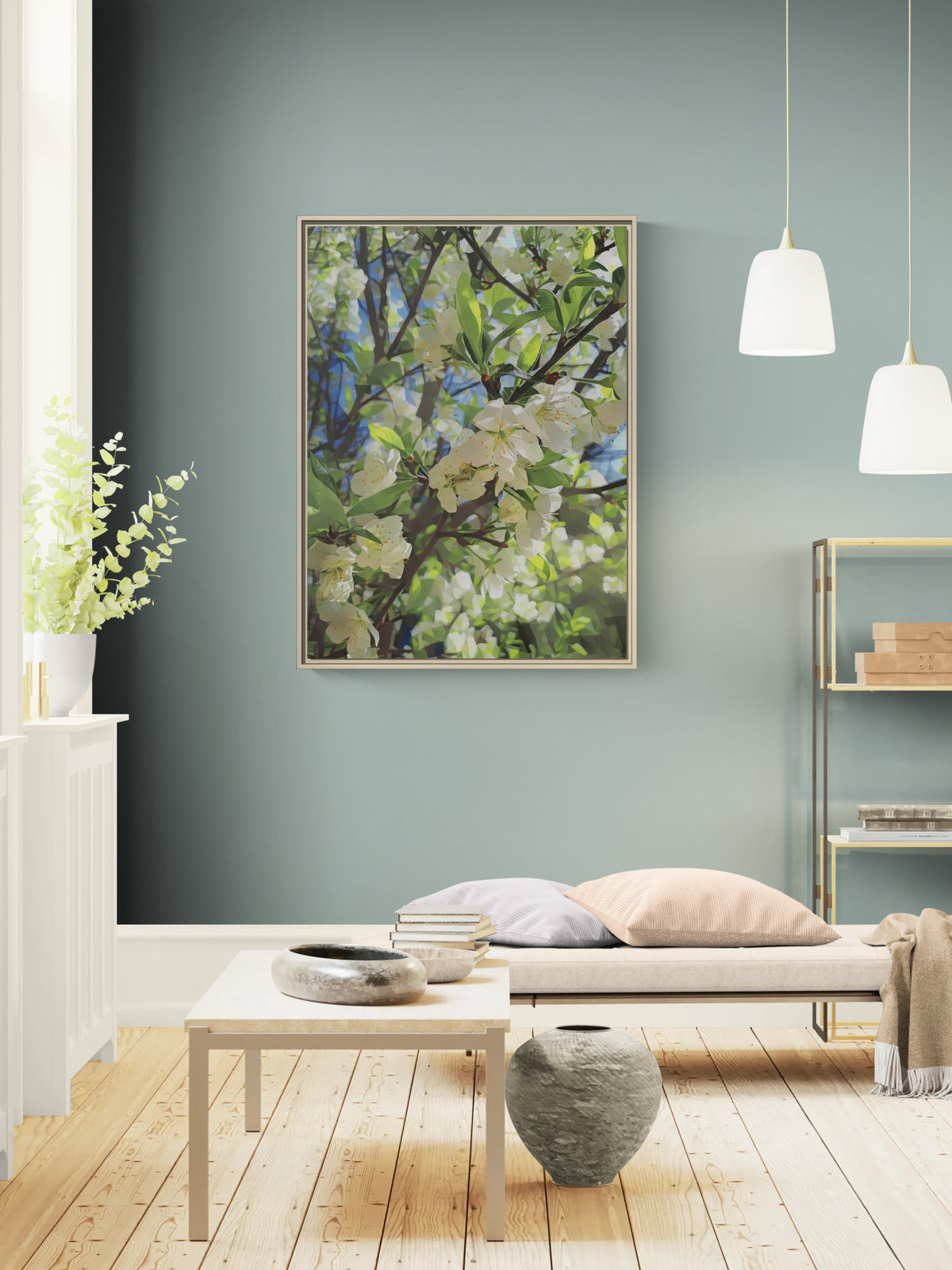 Framed wall art featuring white cherry blossoms on a blue sky background displayed in a modern living room