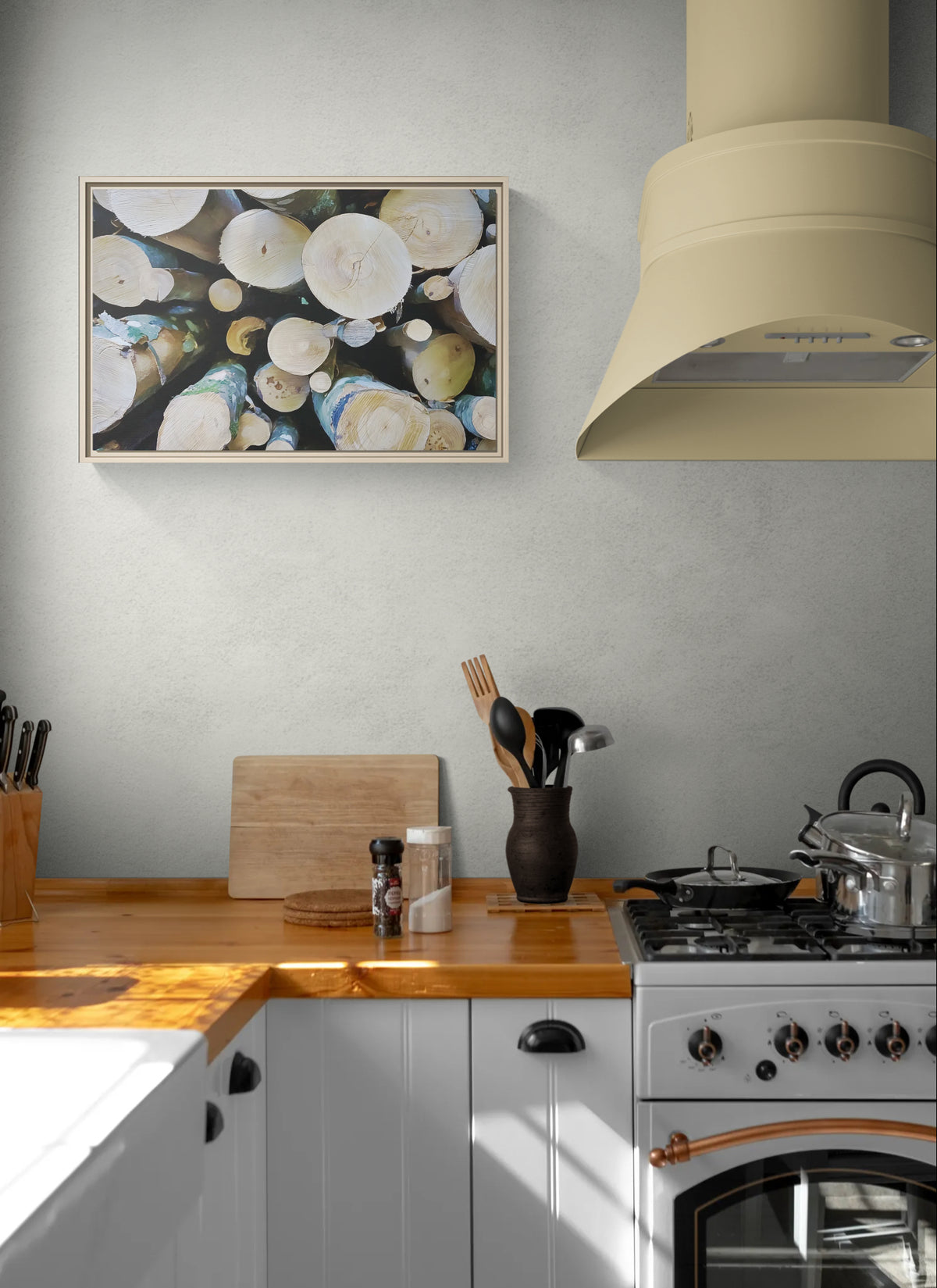 Framed wall art of stacked birch logs hanging in a kitchen above a wooden countertop and stove