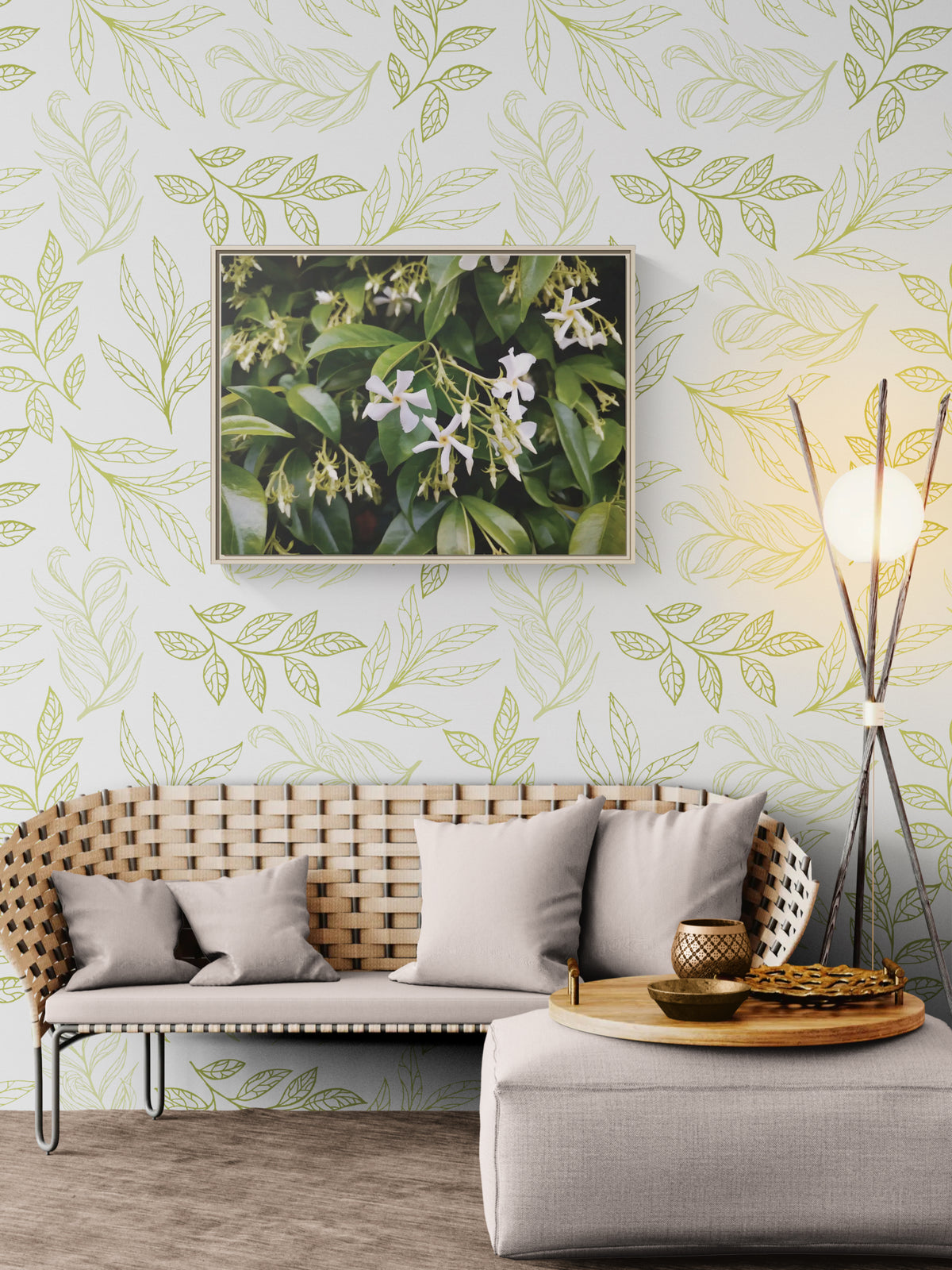 Woven bench with grey cushions against a wall with green leaf line art wallpaper and a framed floral print