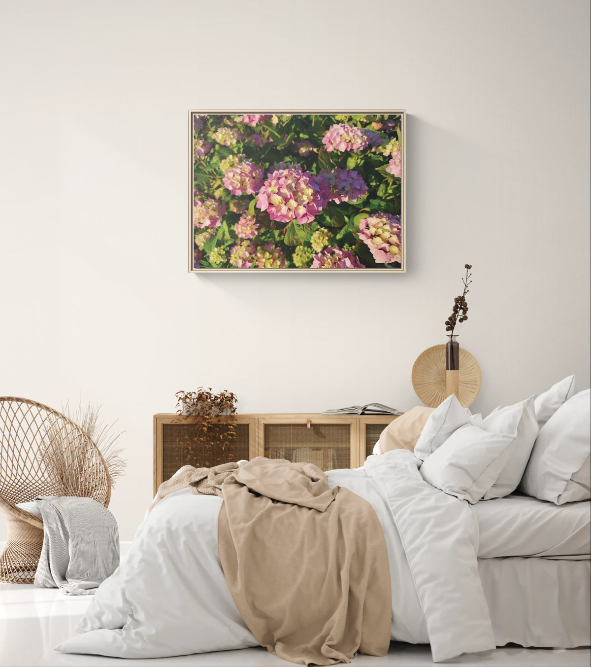 Framed wall art of pink hydrangea flowers hanging above a wooden cabinet in a bedroom