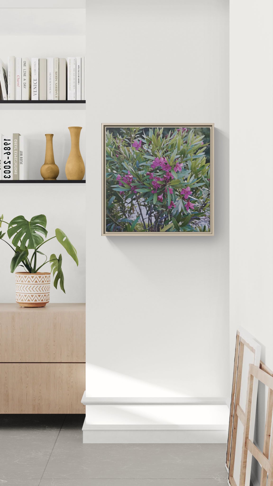 Framed wall art featuring a flowering shrub with purple blossoms hanging on a white wall