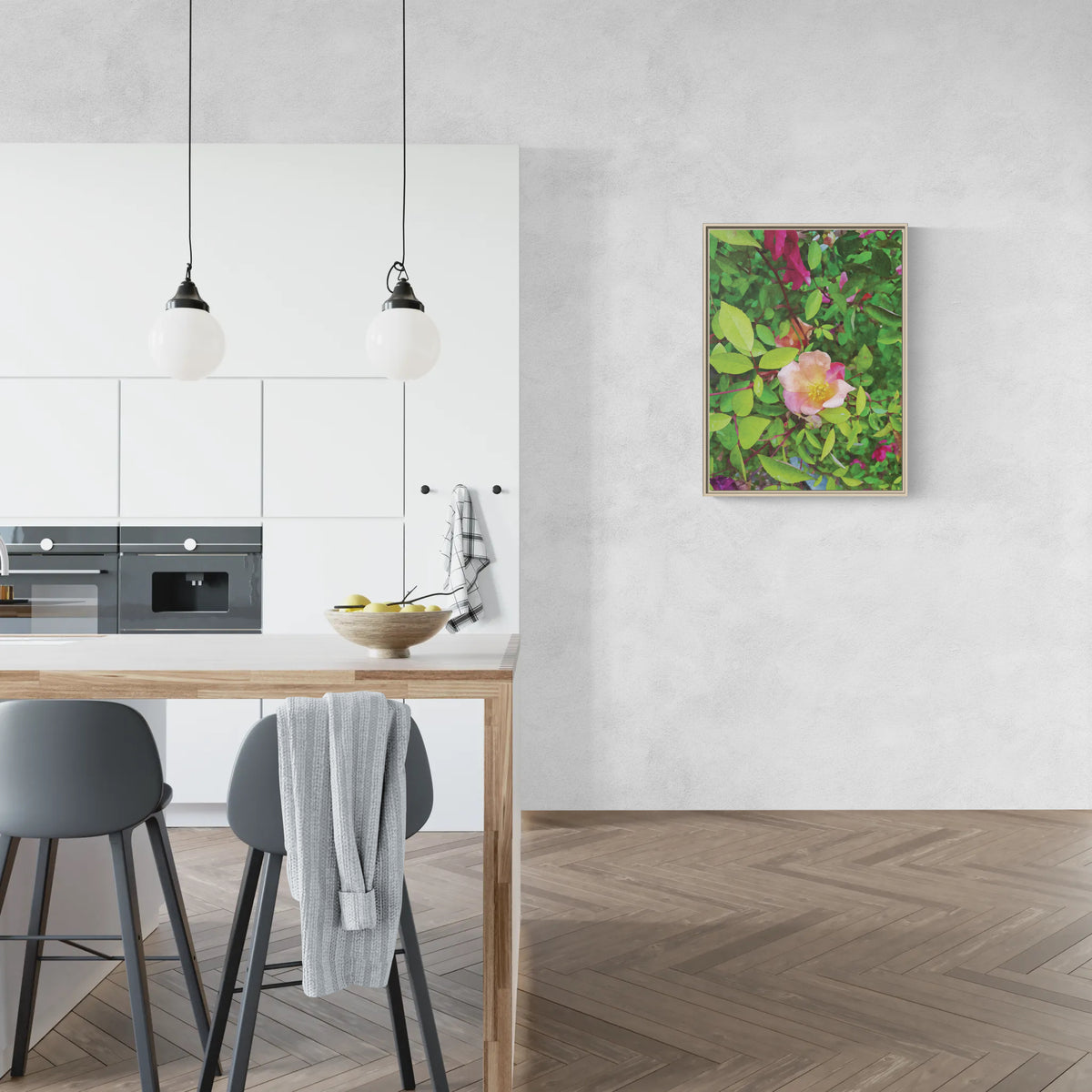 Framed floral wall art hanging in a modern kitchen with white cabinets and wooden floors