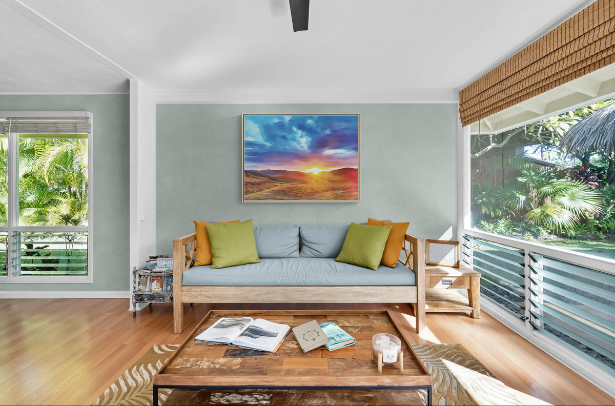 Living room with wooden sofa light blue cushions green and orange pillows and sunset landscape canvas on wall