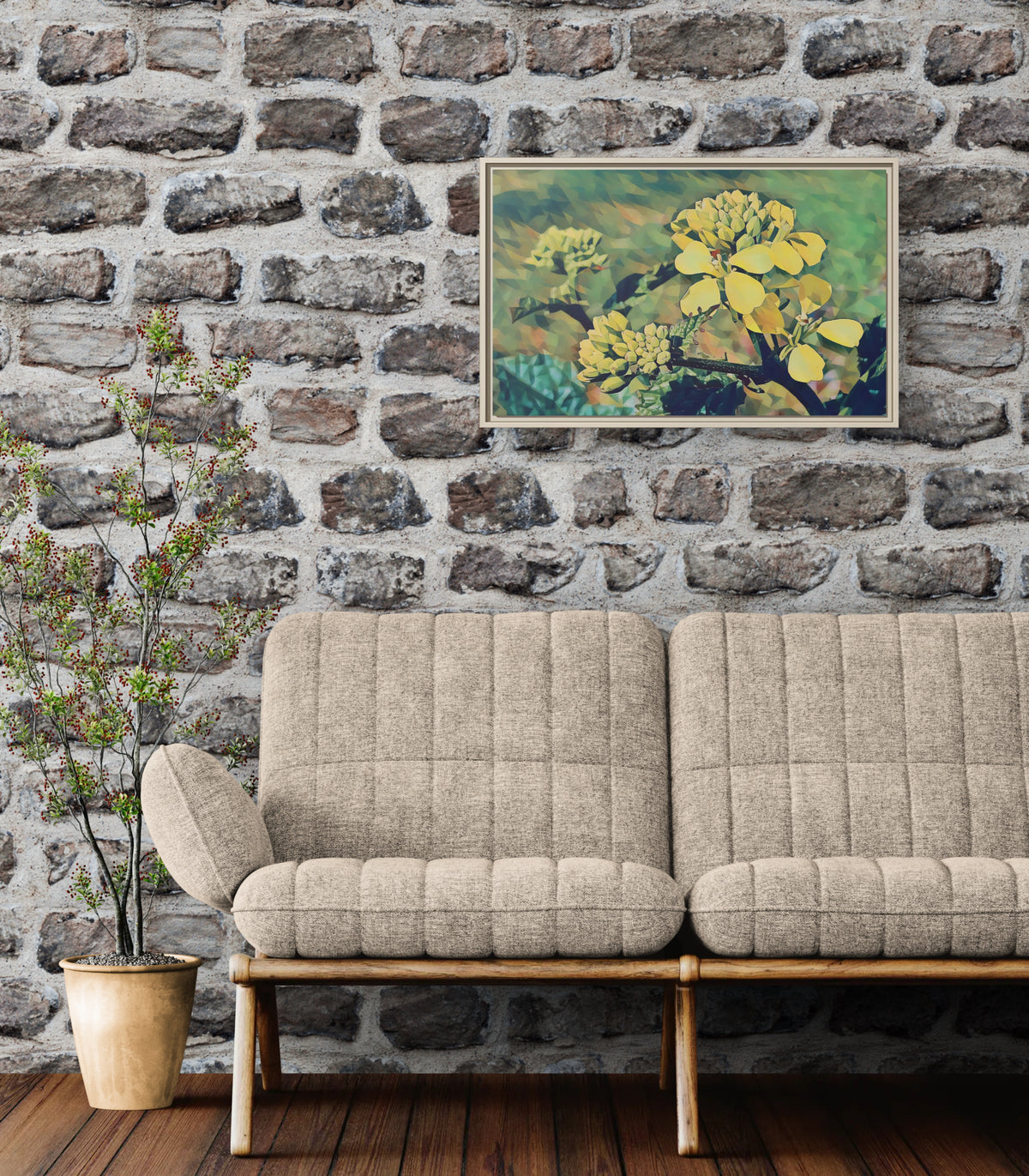 Framed yellow flower wall art hanging above a beige tufted sofa against a stone wall